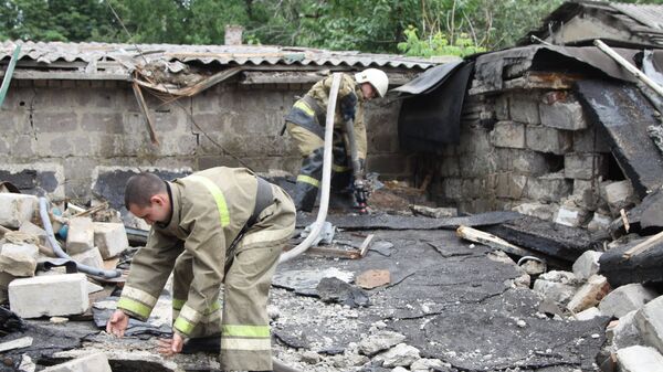 Сотрудники МЧС ДНР устраняют завалы после артиллерийского обстрела в Донецке