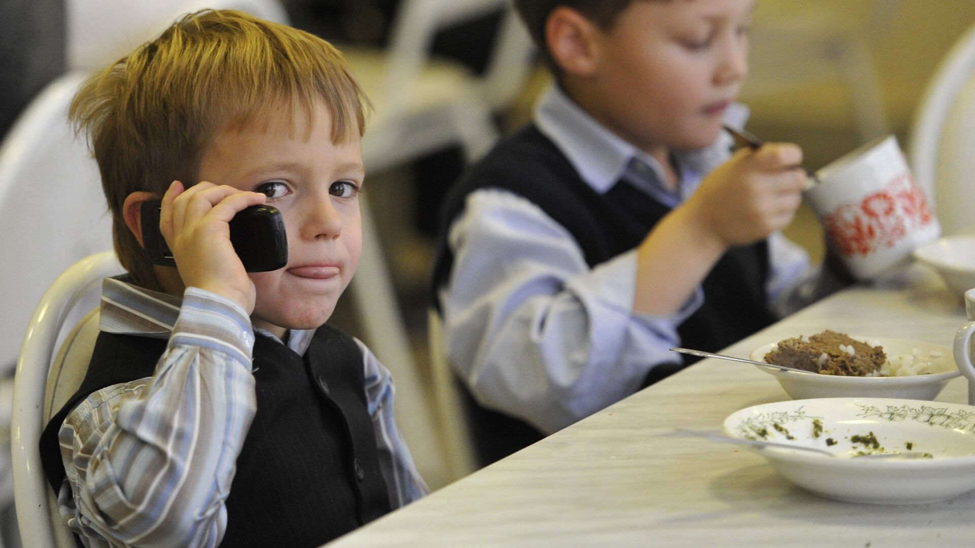 Ребенок с мобильным телефоном в школьной столовой. Архивное фото - РИА Новости, 1920, 15.04.2022