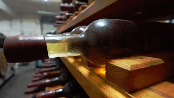 Бутылка с вином на стеллаже погреба винодельни. Архивное фото