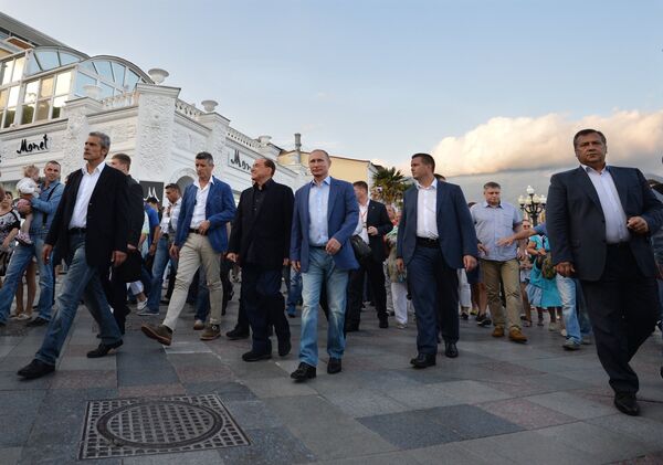 11 сентября 2015 года: с бывшим премьером Италии Сильвио Берлускони (третий слева на первом плане) во время прогулки по ялтинской набережной в Крыму.