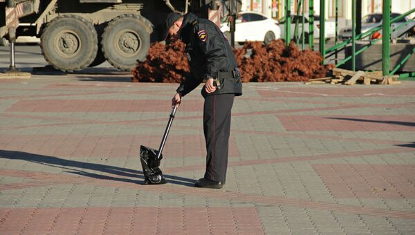 Полицейский осматривает забытый в центре Симферополя пакет