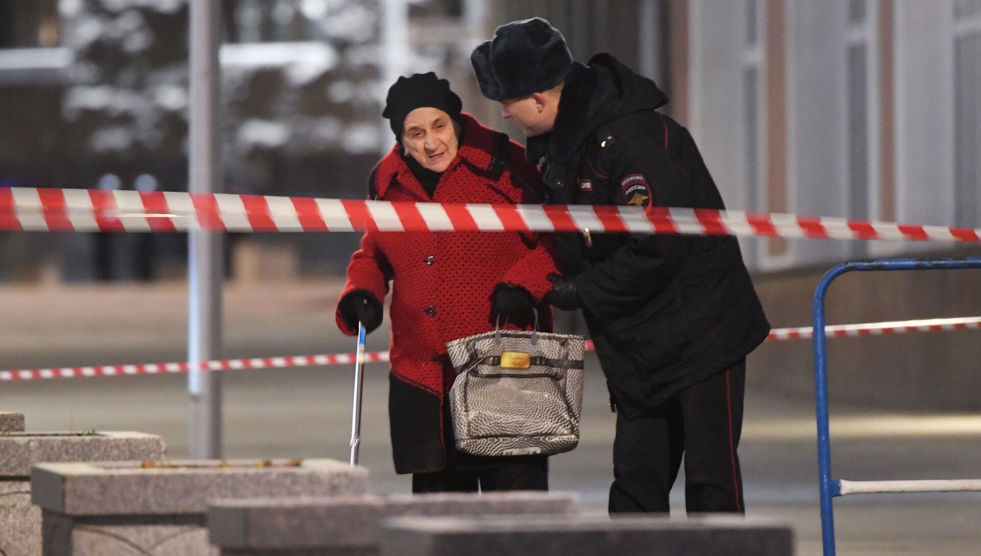 Сотрудник полиции помогает женщине пройти в зоне оцепления недалеко от здания ФСБ на Лубянской площади в Москве, где произошла стрельба - РИА Новости, 1920, 06.03.2021
