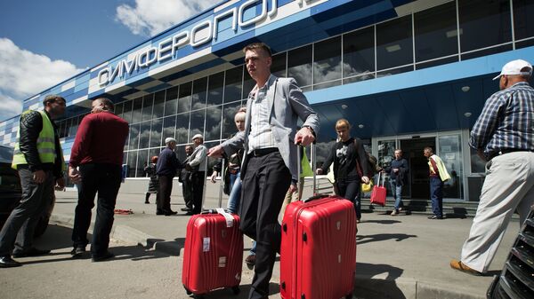 Пассажиры прибывшего самолета выходят из здания международного аэропорта Симферополь