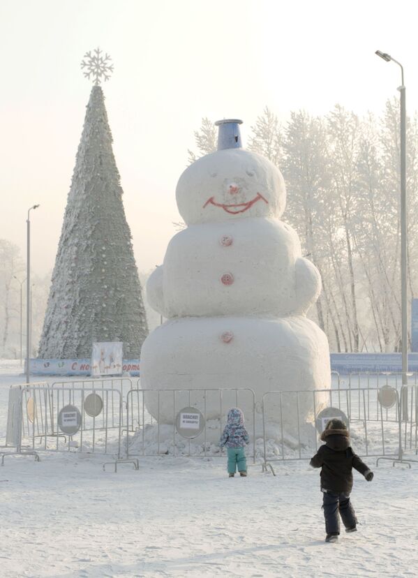 Дети у снеговика в парке города Красноярска.
