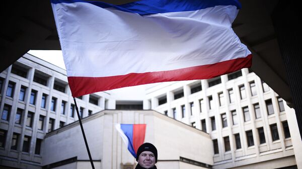 Мужчина с флагом Крыма у здания Госсовета РК