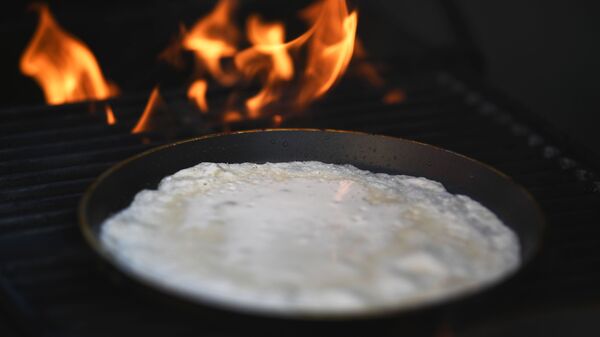 Приготовление блинов на открытии фестиваля Московская масленица на Манежной площади в Москве