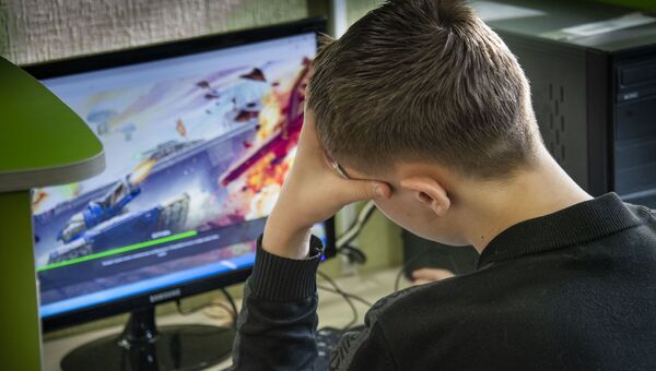 Подросток смотрит в экран монитора, компьютерные игры