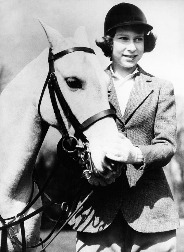 Принцесса Елизавета, будущая королева Елизавета II, в Виндзорском парке со своим белым пони. 1939 год