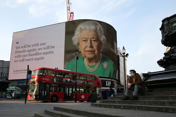 Изображение британской королевы Елизаветы II, выступающей с обращением к нации в связи с эпидемией коронавируса на рекламных щитах на Пикадилли-Цирк в центре Лондона. 9 апреля 2020 года