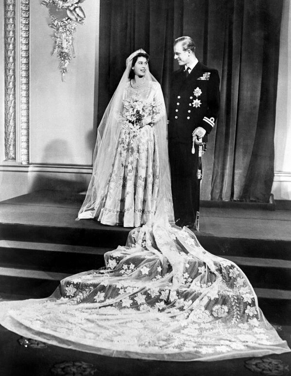 Британская принцесса Елизавета, будущая королева Елизавета II, и Филипп, герцог Эдинбургский позируют в день своей свадьбы в Букингемском дворце в Лондоне 20 ноября 1947 года.