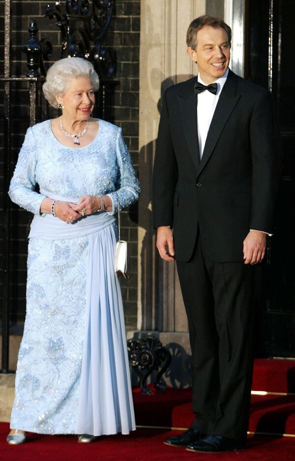 Премьер-министр Тони Блэр в Лондоне 29 апреля 2002 года приветствует британскую королеву Елизавету II на Даунинг-стрит, № 10.